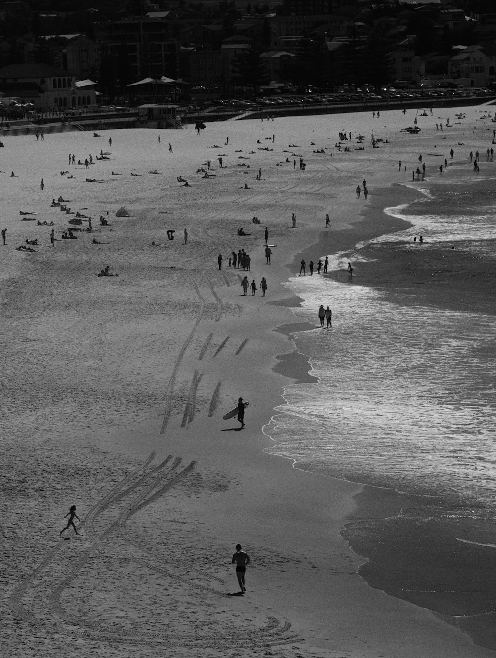 a group of people walking along a beach next to the ocean