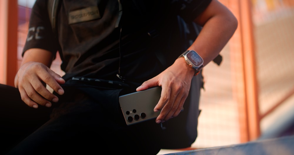 a man sitting on a bench holding a watch