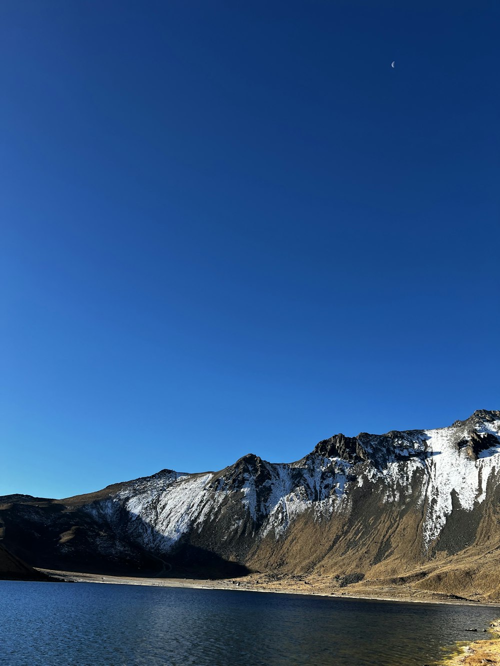 a mountain range with a lake in the foreground