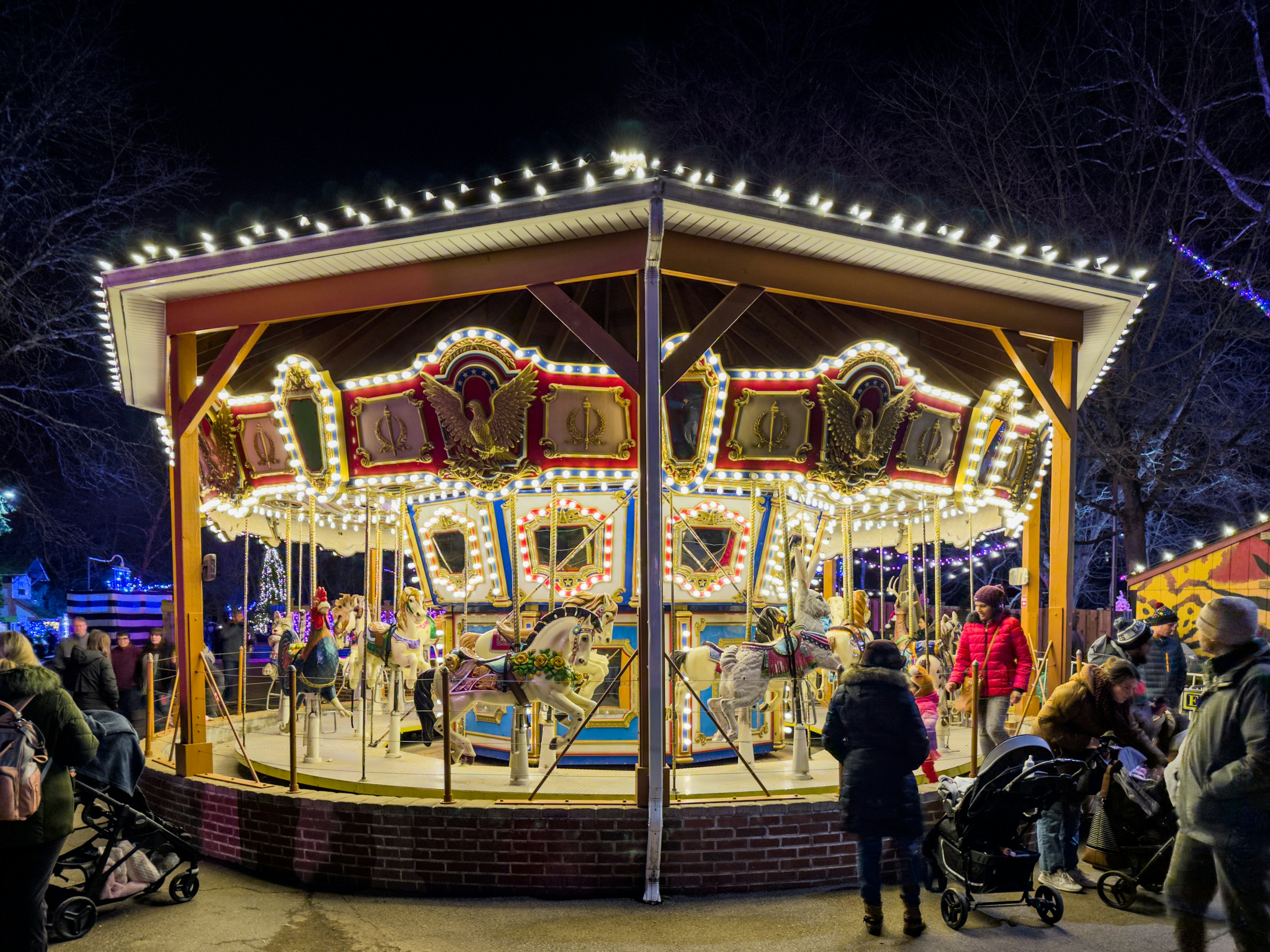 a merry go round at night with people walking around, Merry go round