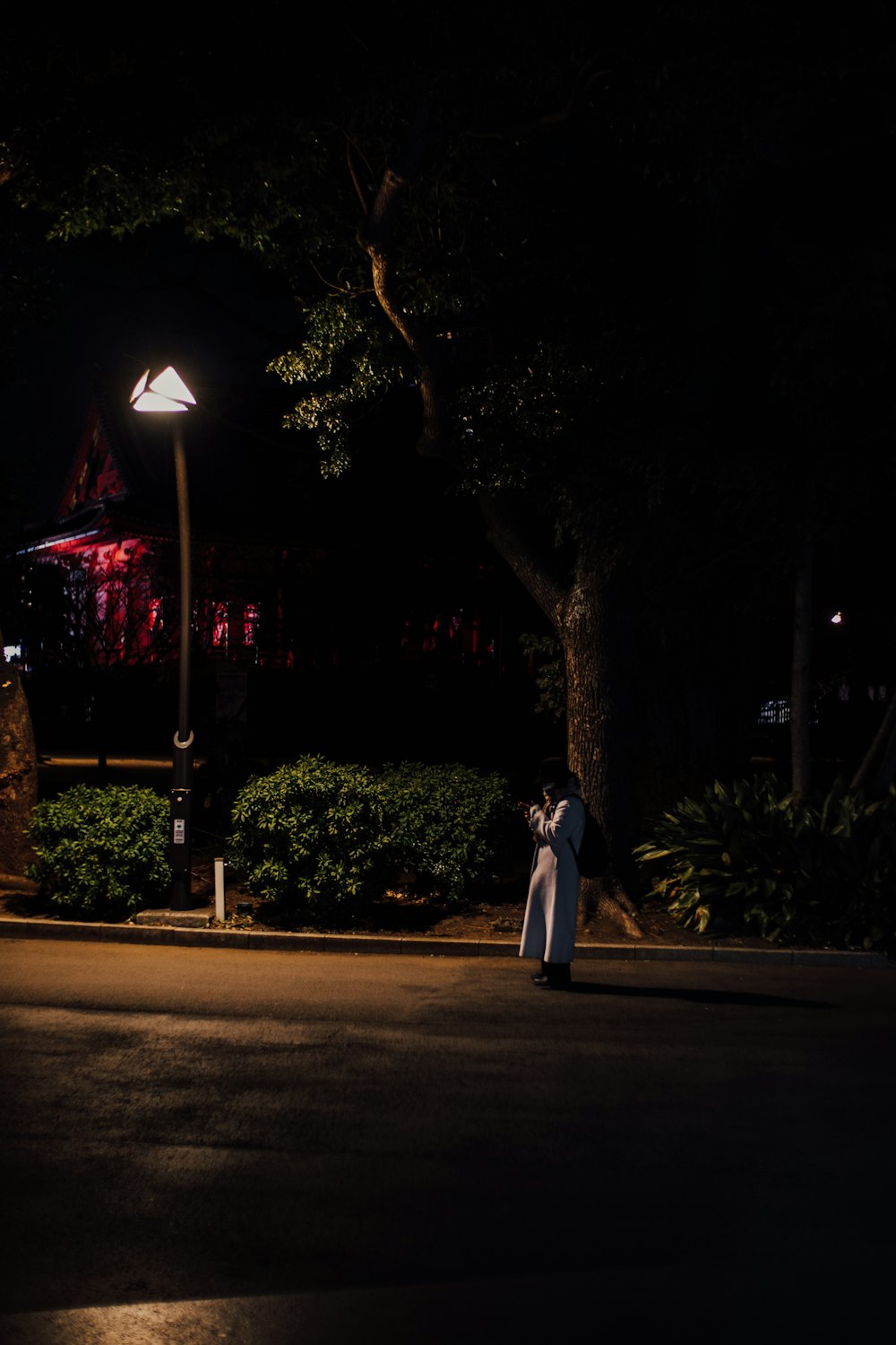 una persona parada en una calle por la noche