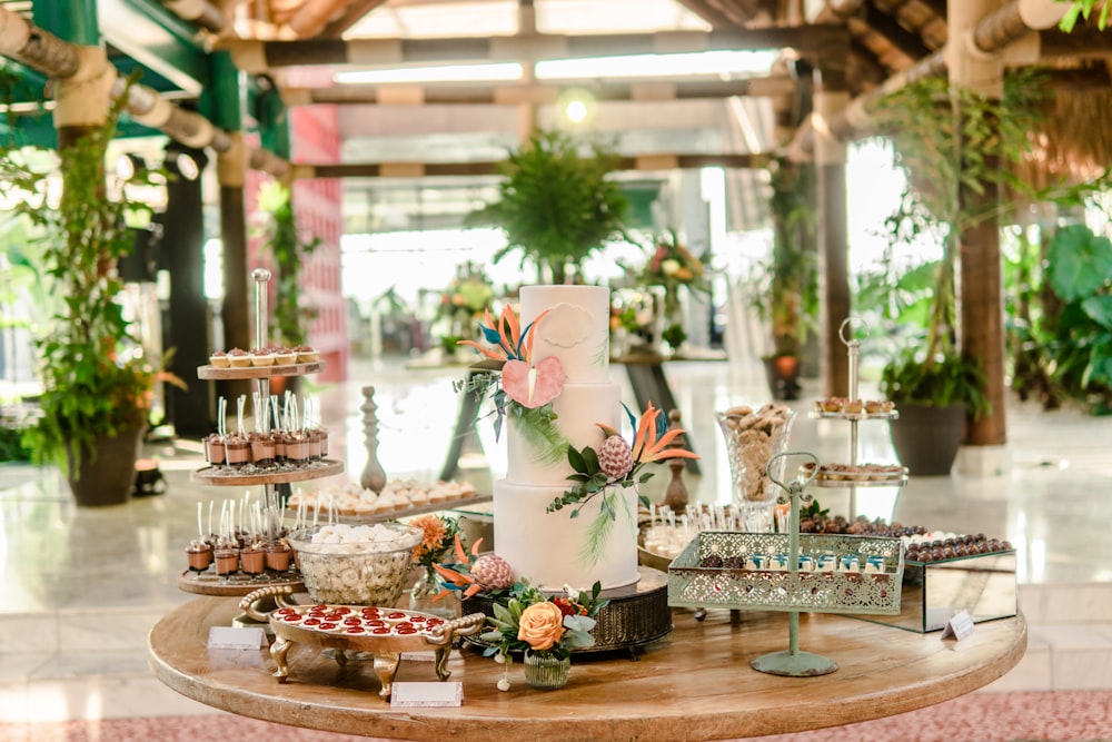 a table topped with lots of desserts on top of a wooden table