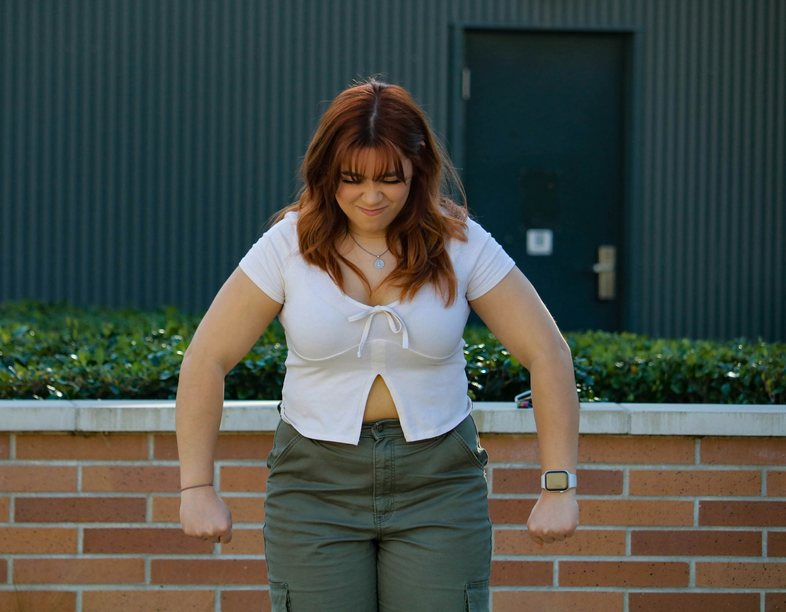a woman standing in front of a brick wall