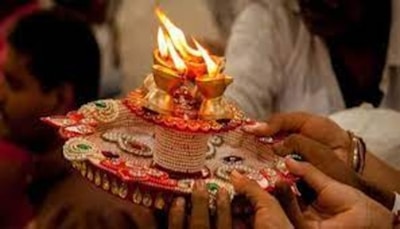 Close-up of hands distributing food plates with religious decorations in the background.