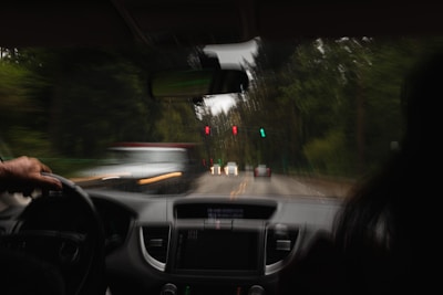 a person driving a car on a road with traffic lights