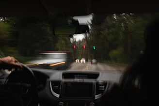 a person driving a car on a road with traffic lights