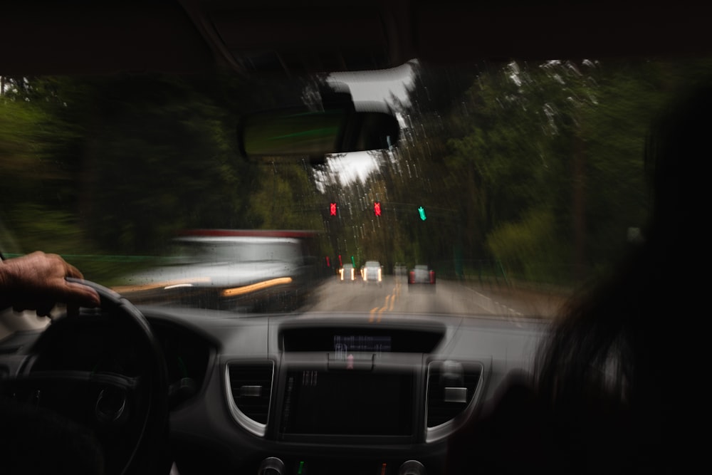 a person driving a car on a road with traffic lights