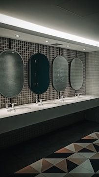 Interior view of a luxury restroom trailer showing polished sinks, mirrors, and spacious stalls with soft lighting.