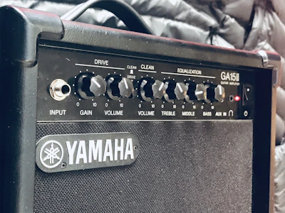 Stylish bass amplifier with illuminated control knobs and a charcoal background highlighting its premium design.