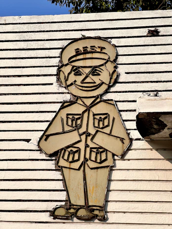 Vintage 1930s-style mascot illustration of a friendly house boy holding cleaning tools with a confident smile.