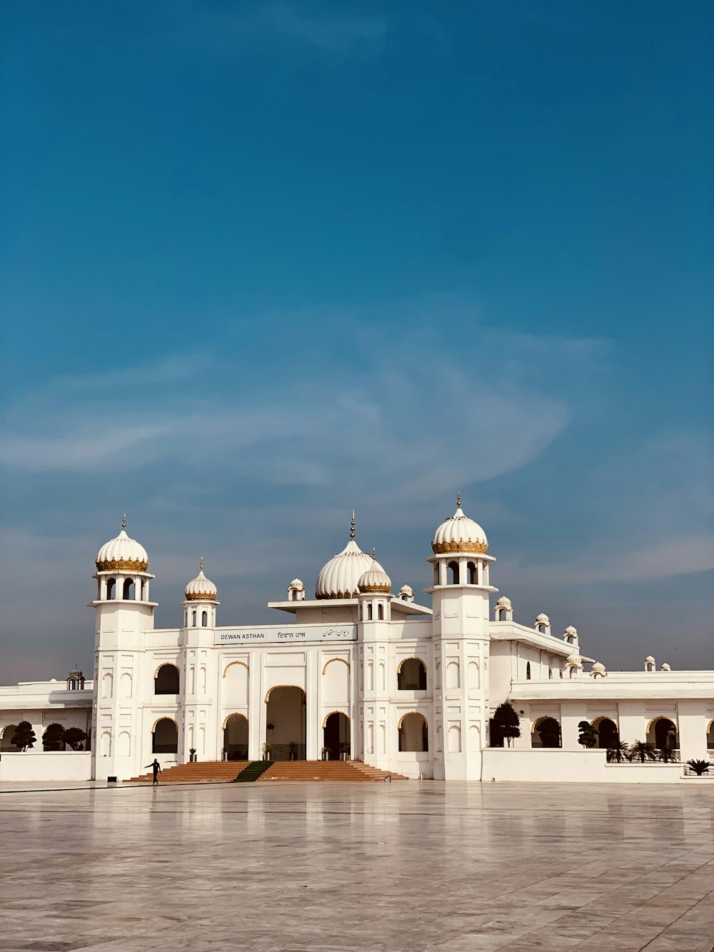 a large white building sitting on top of a cement field