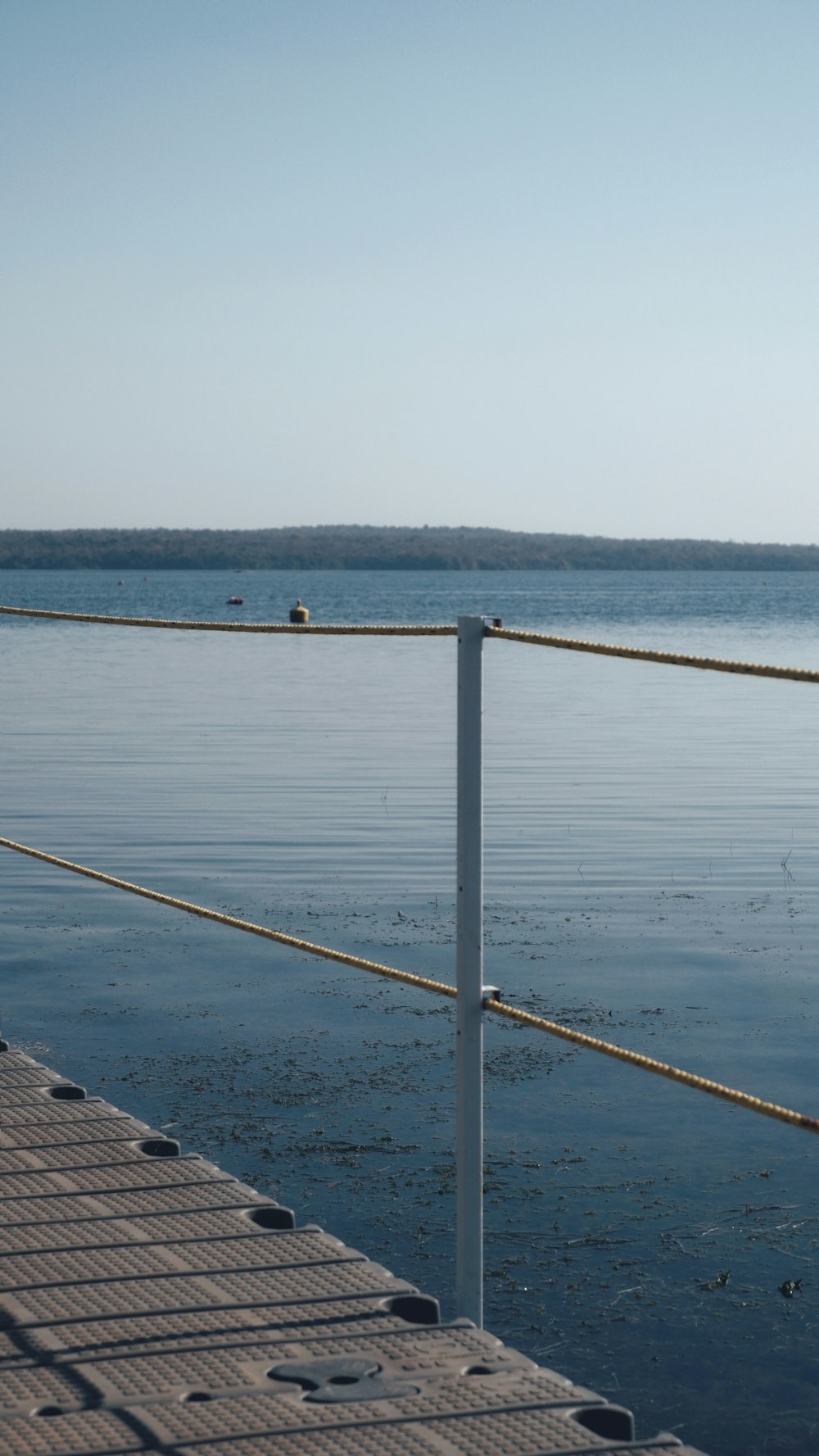 a bench sitting on the side of a pier next to a body of water