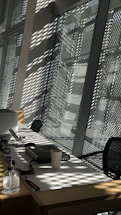 A modern office desk with a laptop open showing a contact form on screen, surrounded by samples of SolarTek curtain fabrics.