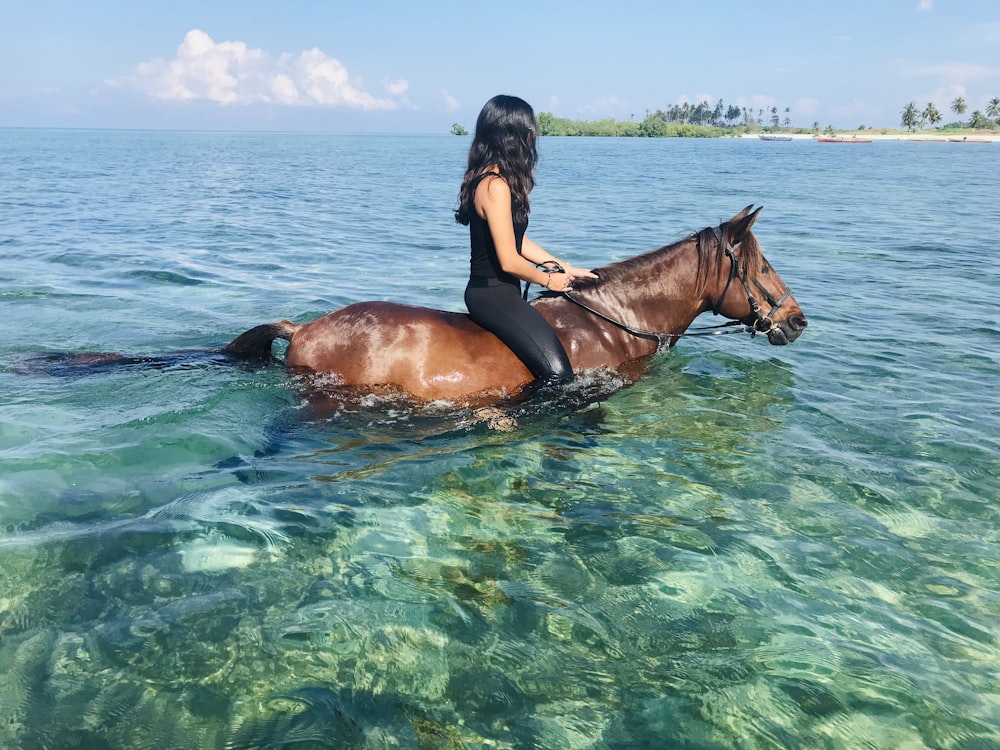 a woman is riding a horse in the water