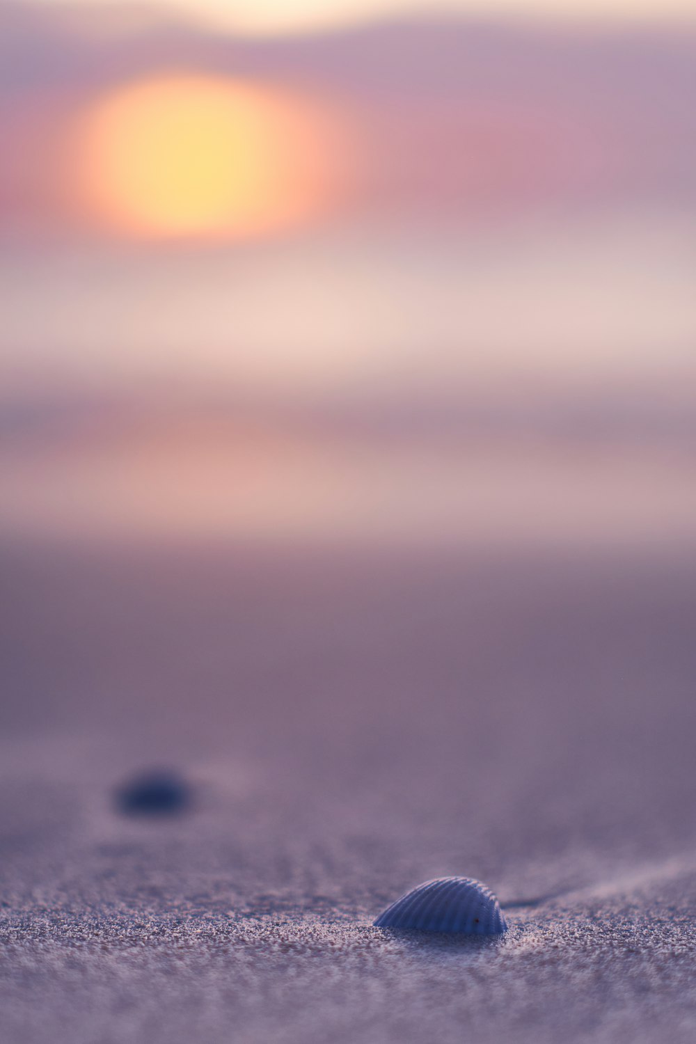 a close up of sand with a sunset in the background