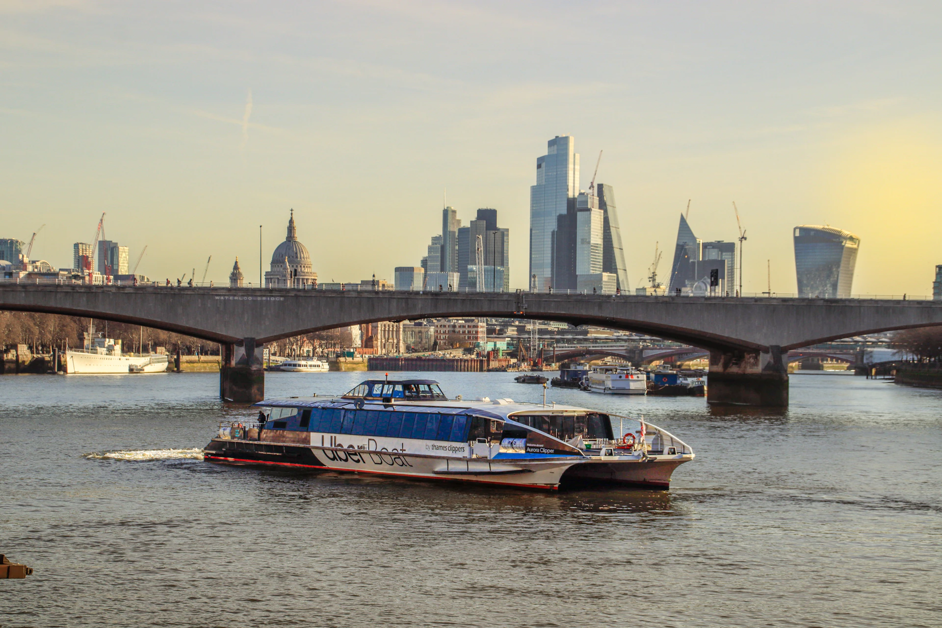 a boat traveling down a river next to a bridge