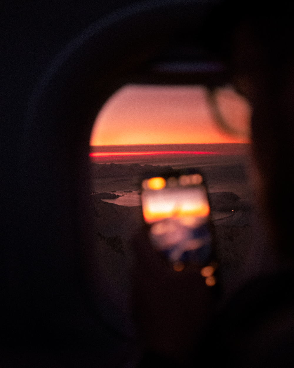 a person taking a picture of a sunset with a cell phone