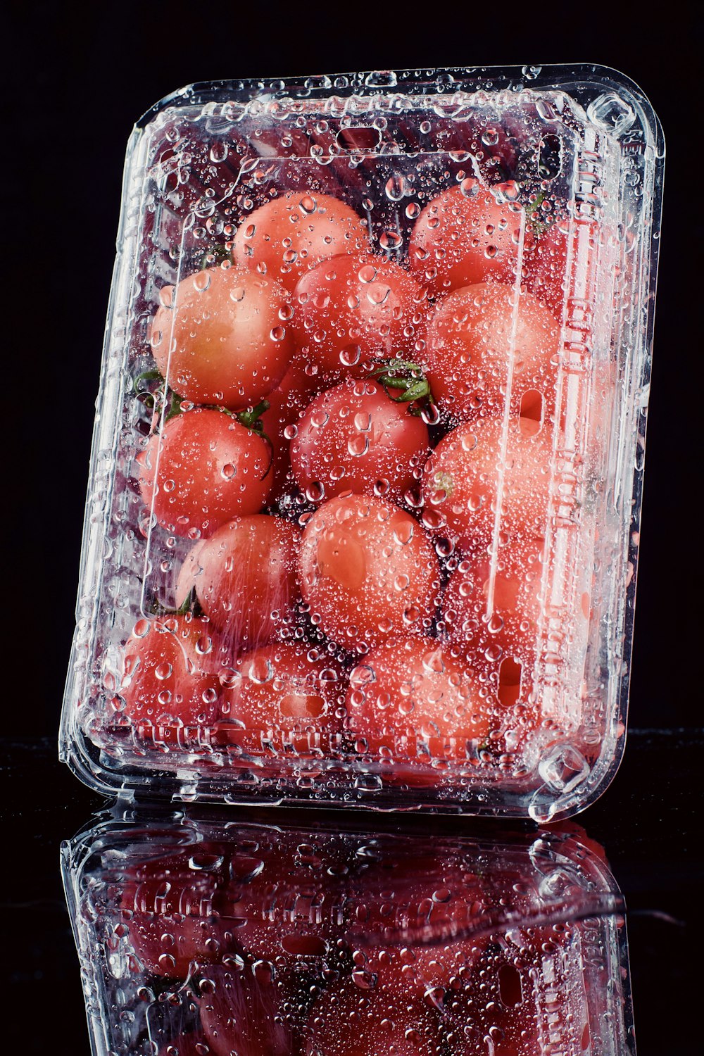a plastic container filled with lots of tomatoes