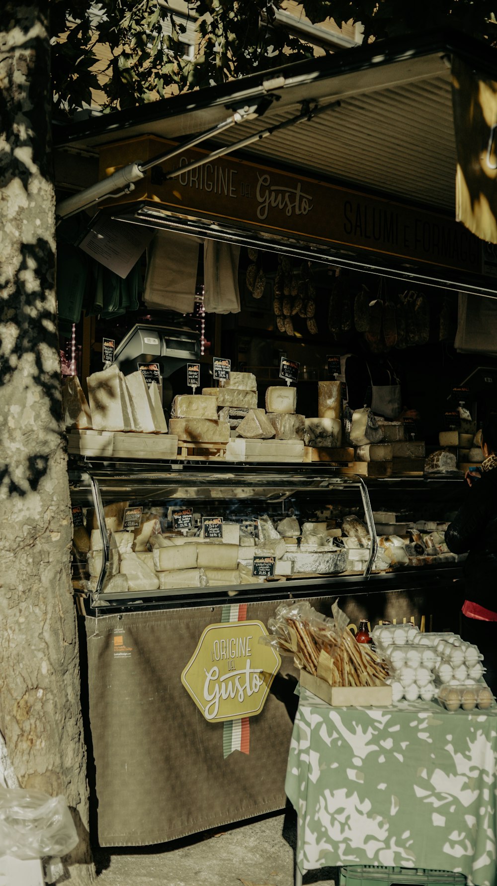 a food stand with cheeses and other items on display