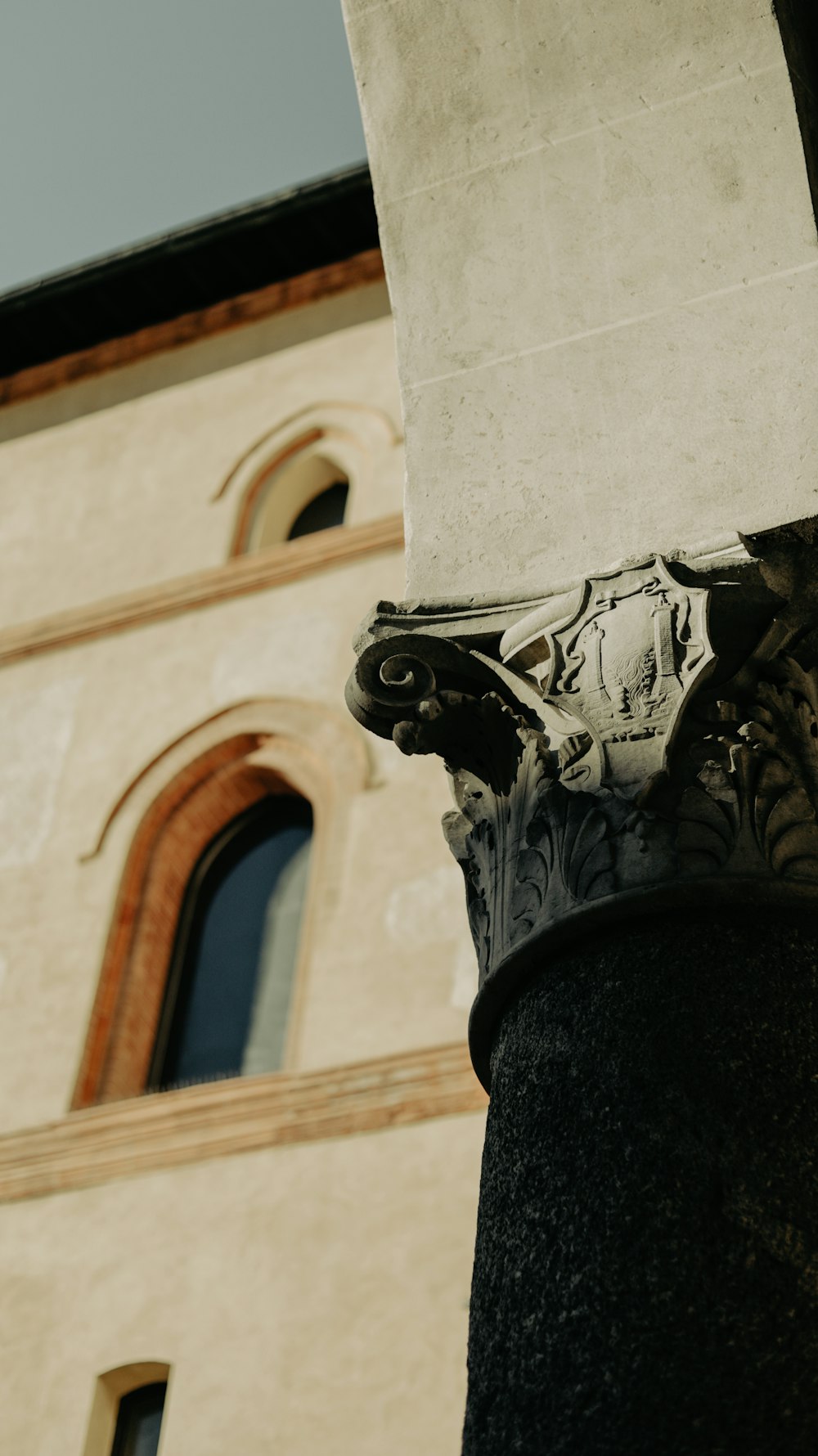 a close up of a stone column with a building in the background