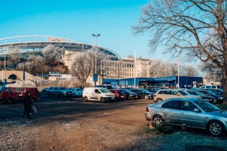 A spacious parking lot filled with parked cars under a clear sky.