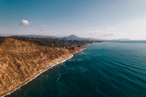 an aerial view of the ocean and mountains