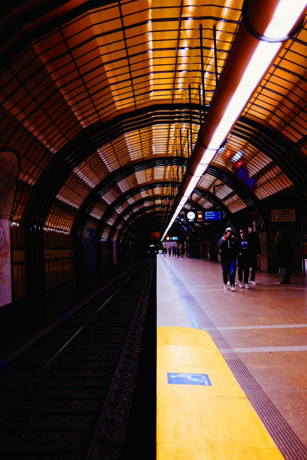 a train station with people standing on the platform