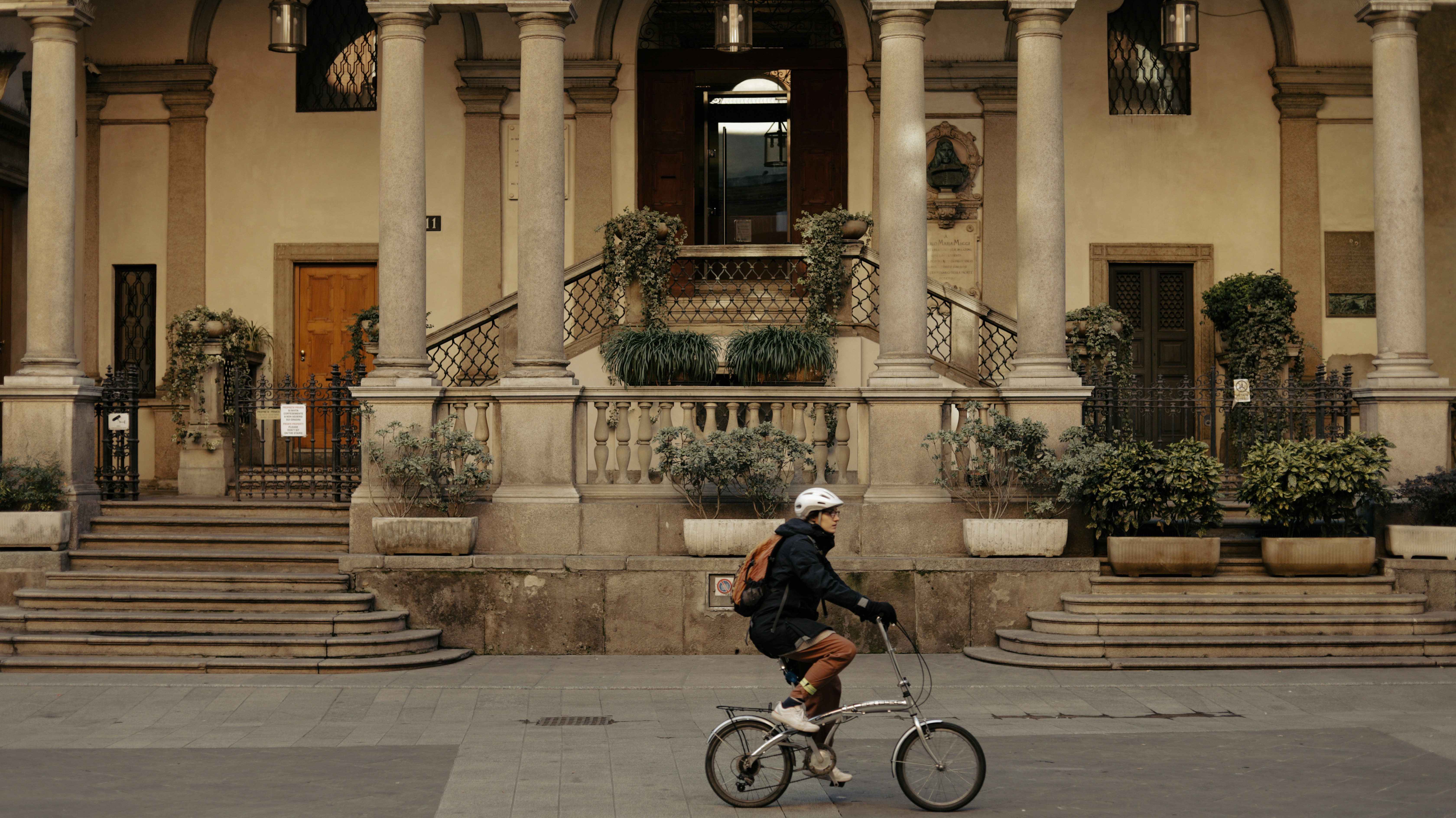 una persona che va in bicicletta di fronte a un edificio