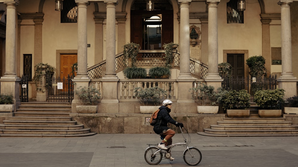 a person riding a bike in front of a building