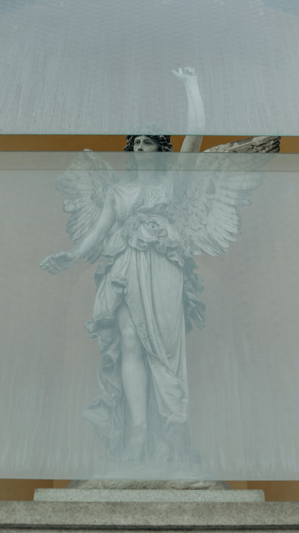 a statue of an angel in a glass case