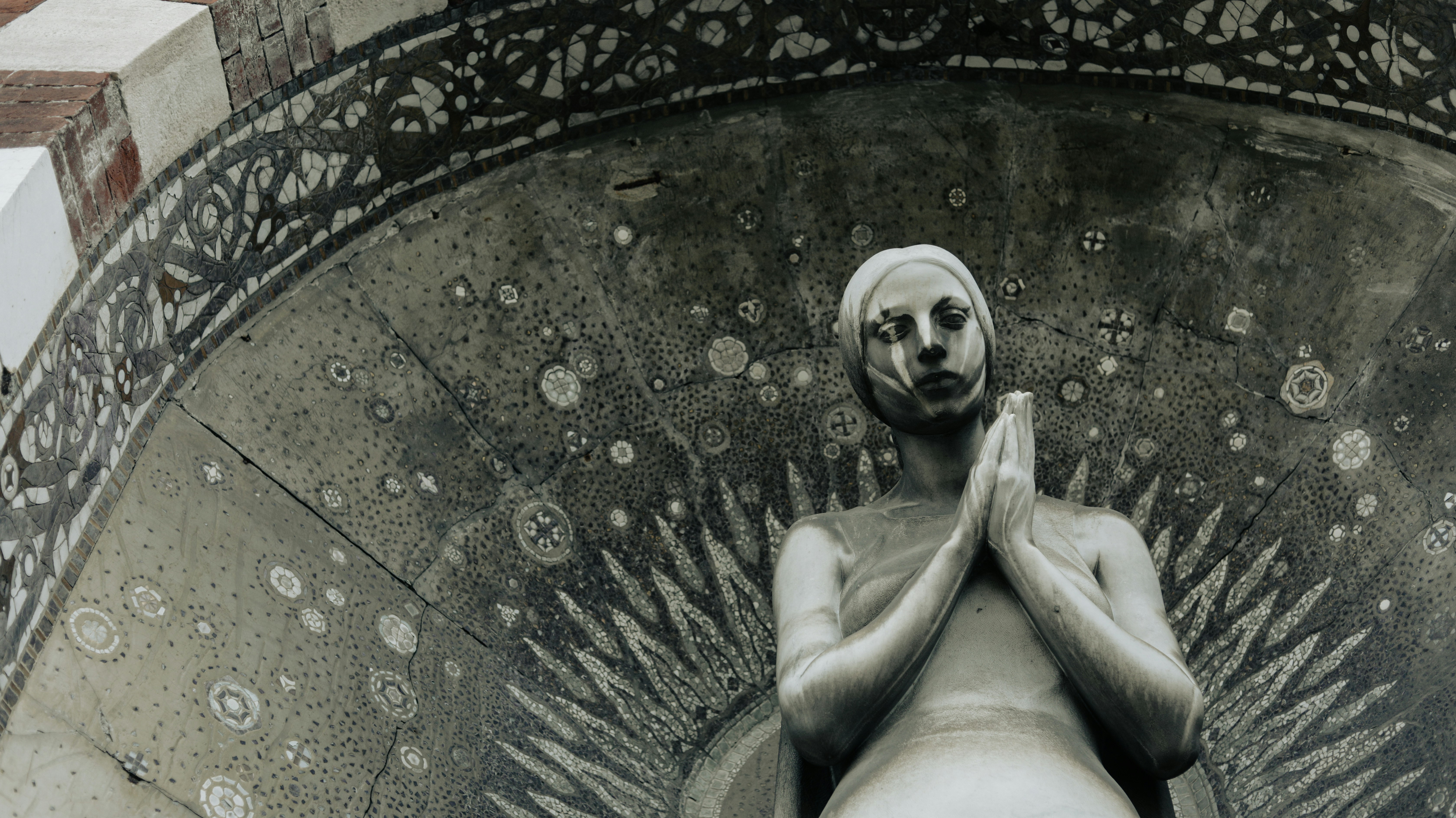 a statue of a man with his hands folded in front of him