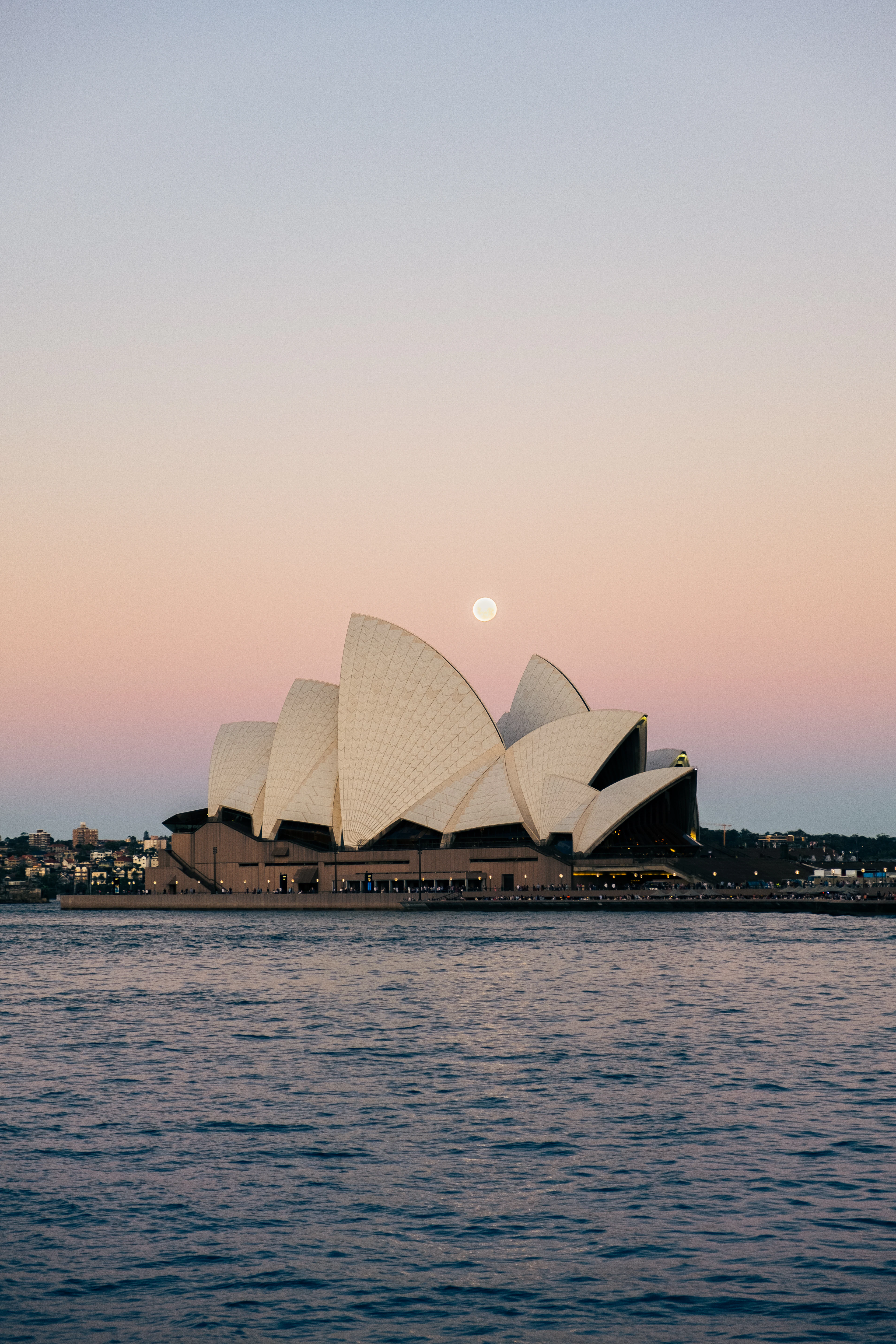 Sydney Opera House across the harbour beneath a rising moon