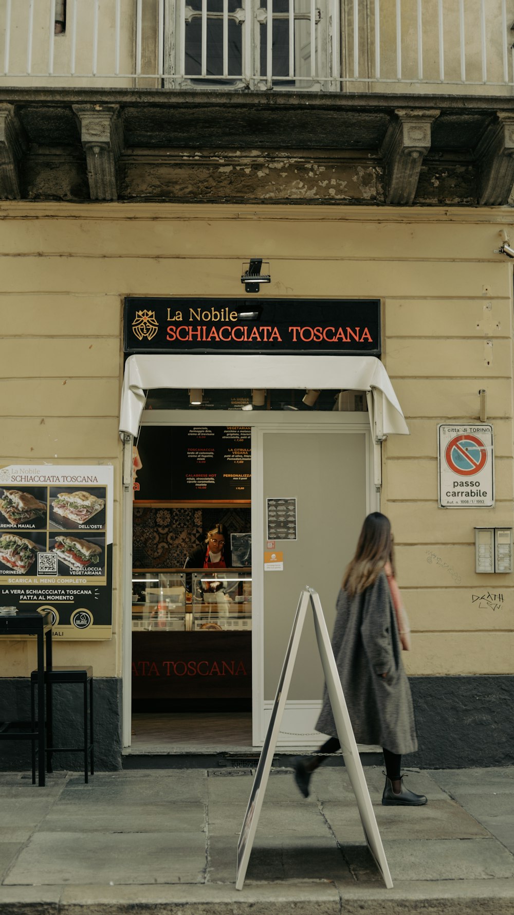 a woman is walking past a store front