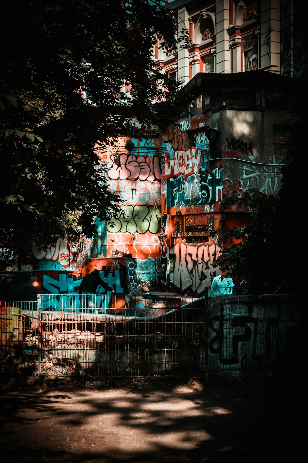 a building covered in graffiti next to a tree