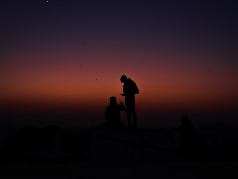 a couple of people standing on top of a hill