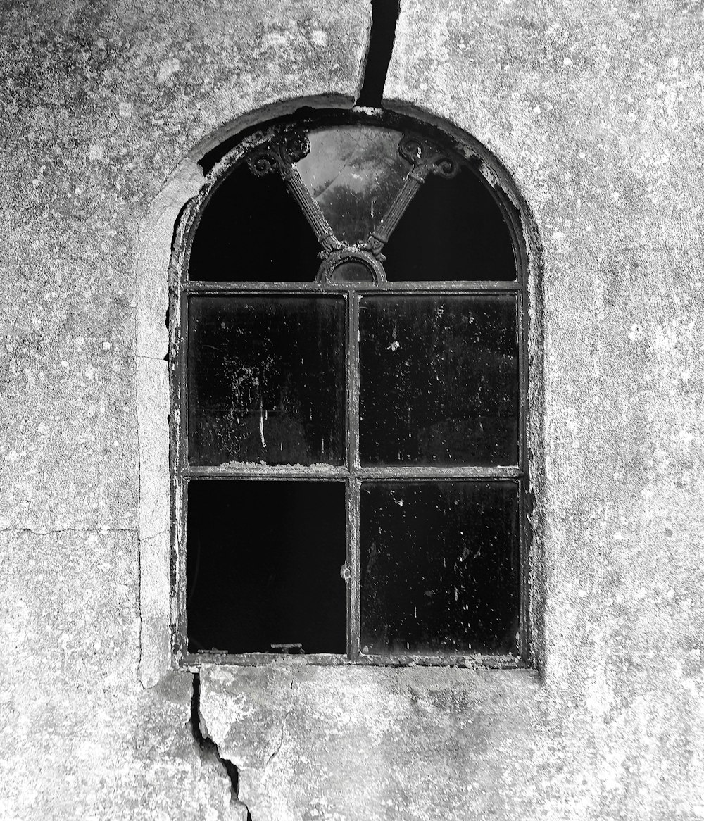 a black and white photo of a broken window