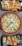 A wooden table showcases a round vegetable pizza topped with colorful vegetables like broccoli, bell peppers, tomato, and black olives, surrounded by golden cheese. Near the pizza, a platter of crispy seasoned fries drizzled with white sauce, and another platter with golden-brown fried spring rolls filled with a savory stuffing on a bed of shredded cabbage.