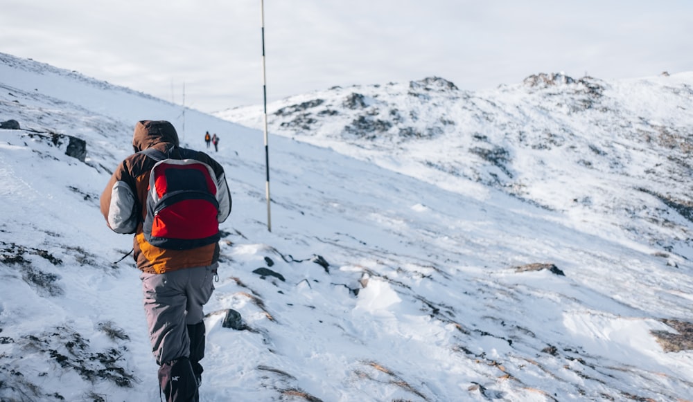 a man walking up a snow covered mountain