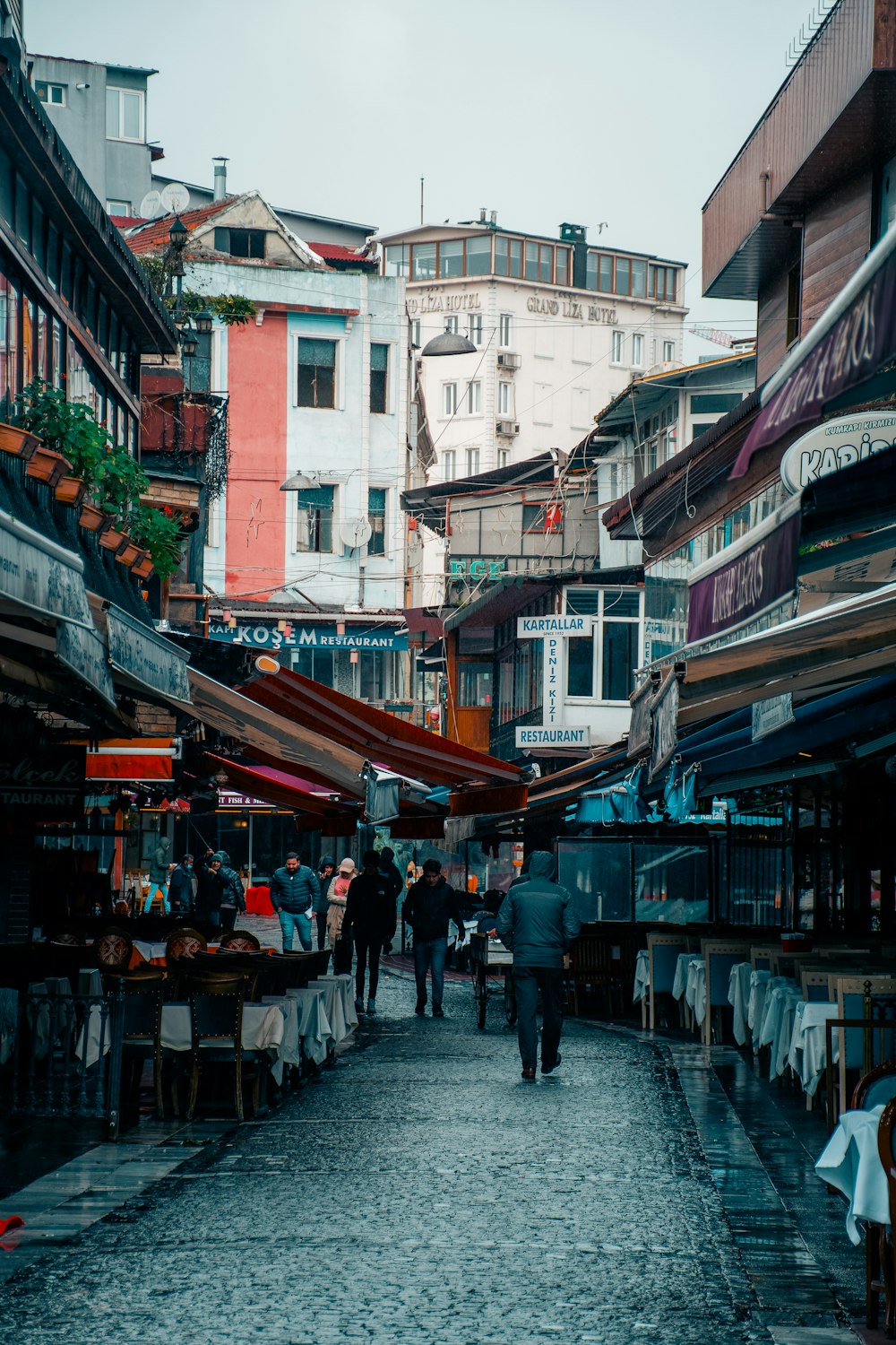 a group of people walking down a cobblestone street