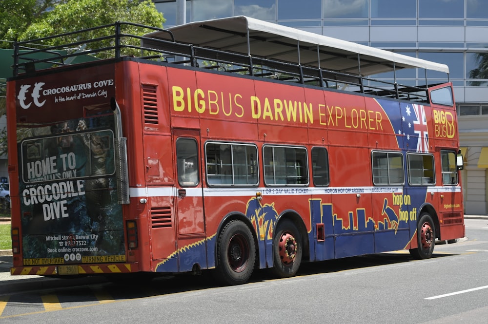 a red double decker bus parked in front of a building