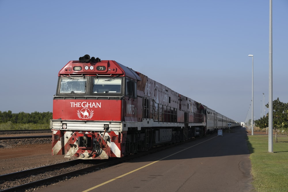 a red and white train traveling down train tracks