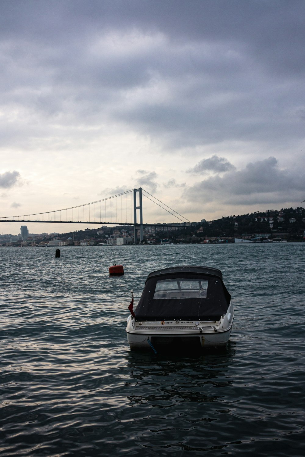 a boat floating in the water near a bridge