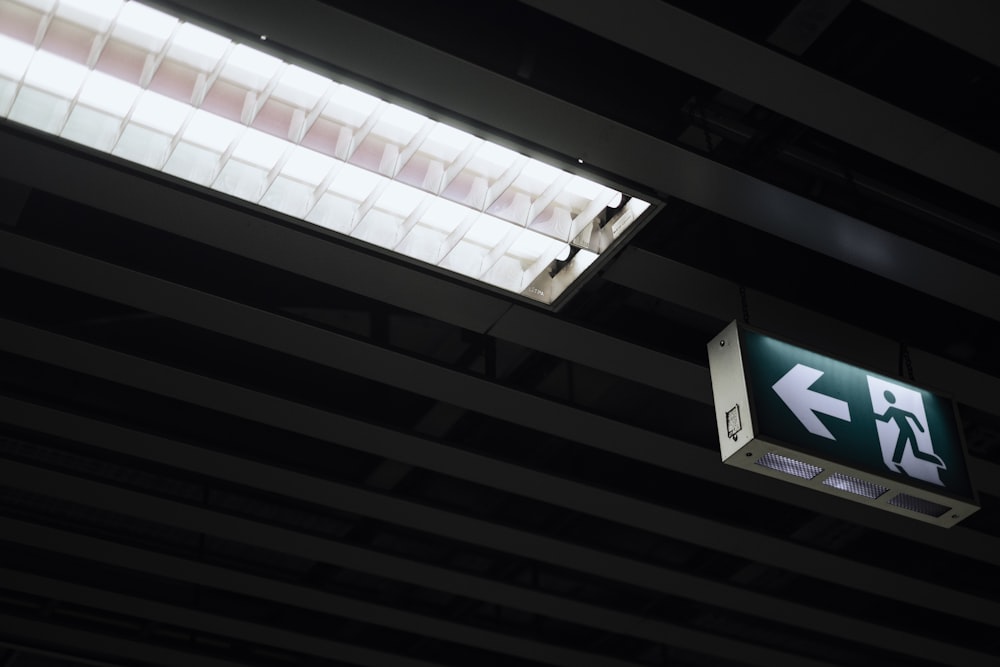 a green sign hanging from the ceiling of a building