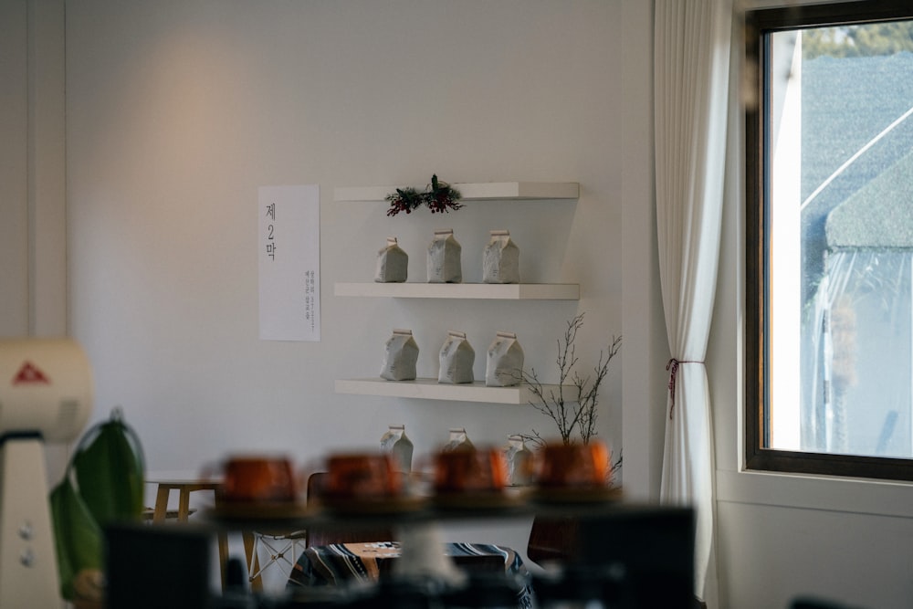 Foto Una cocina con una ventana y estantes llenos de platos – Imagen Diseño  de interiores gratis en Unsplash