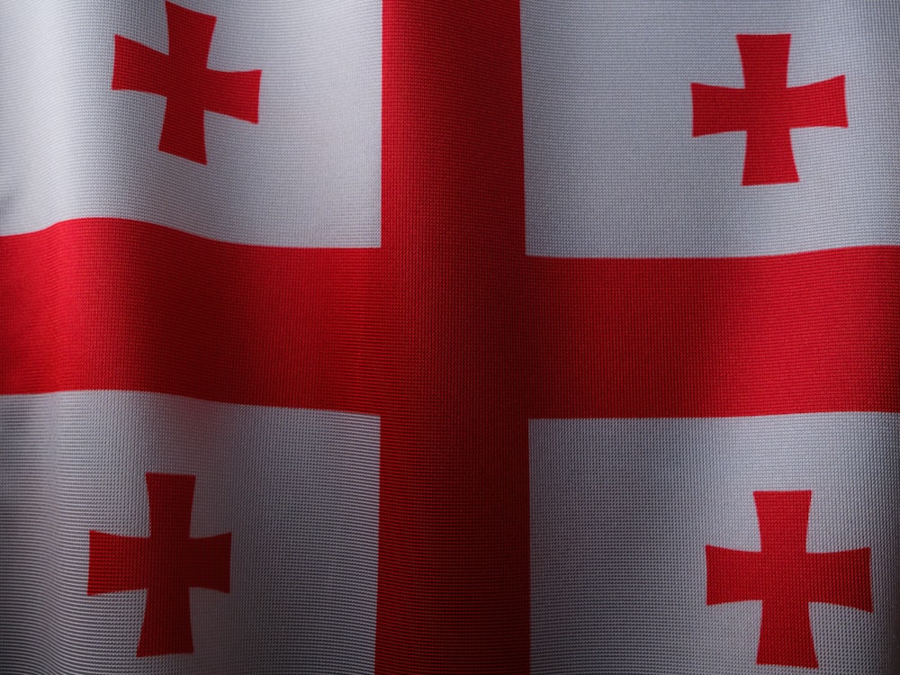 un drapeau rouge et blanc avec une croix dessus
