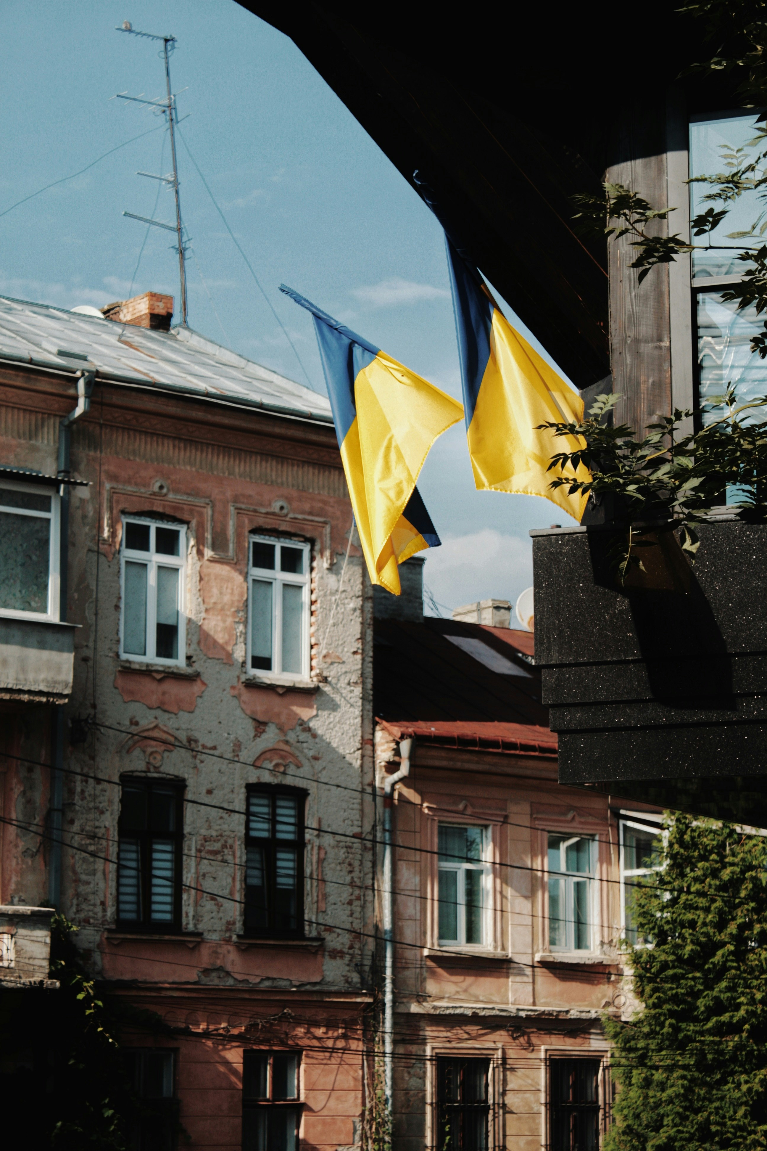 a yellow and blue flag flying in front of a building