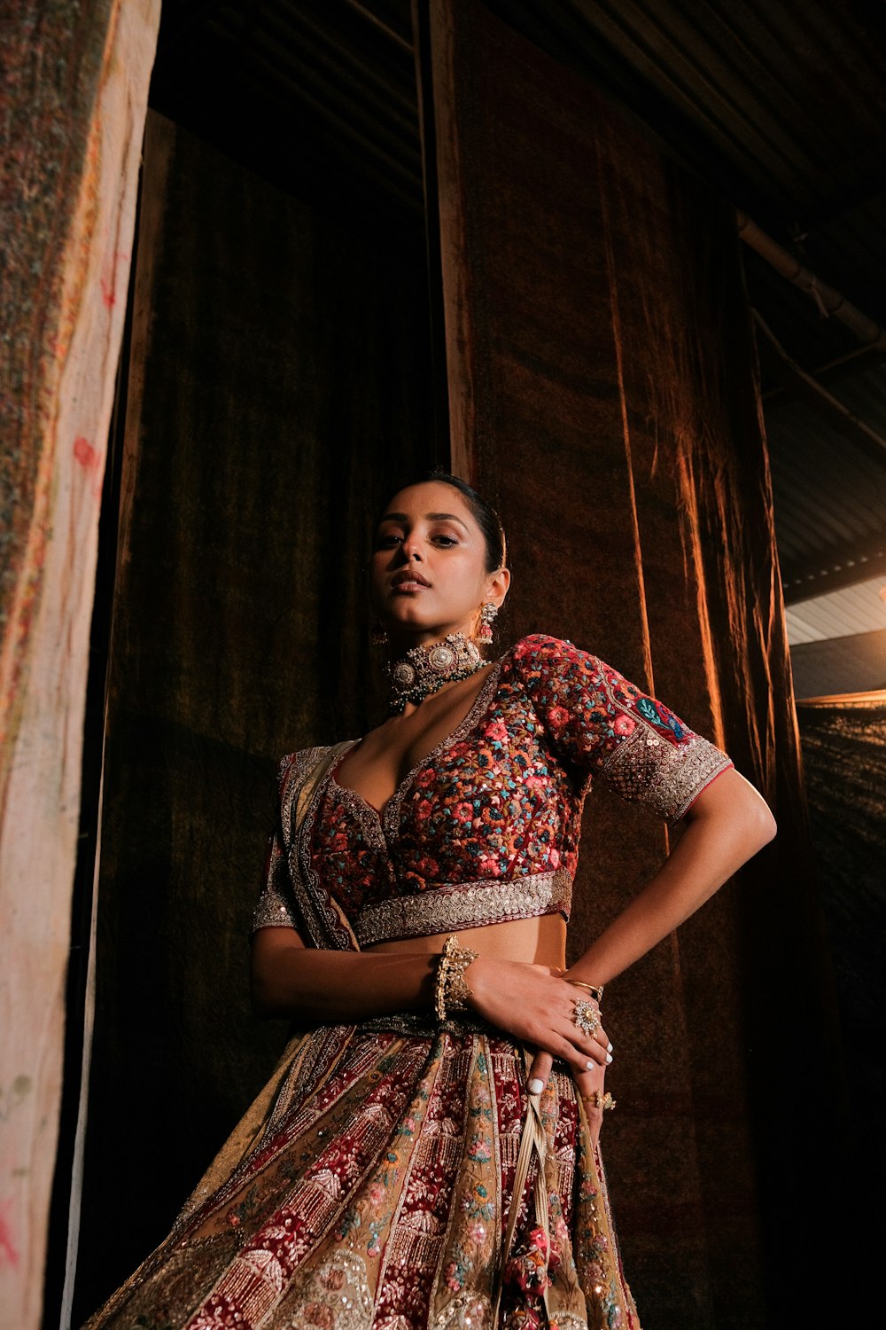 a woman in a dress standing in front of a curtain