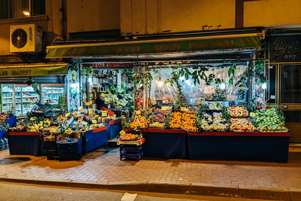 a fruit stand on a city street at night