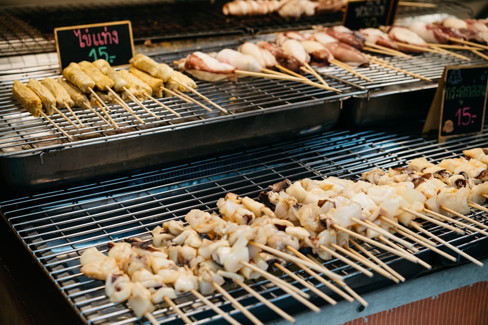 a bunch of skewers of food on a grill