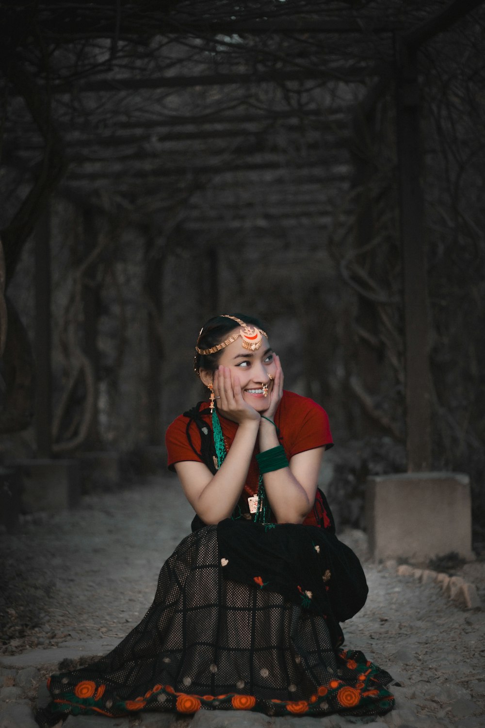 a woman sitting on the ground with her hands on her face